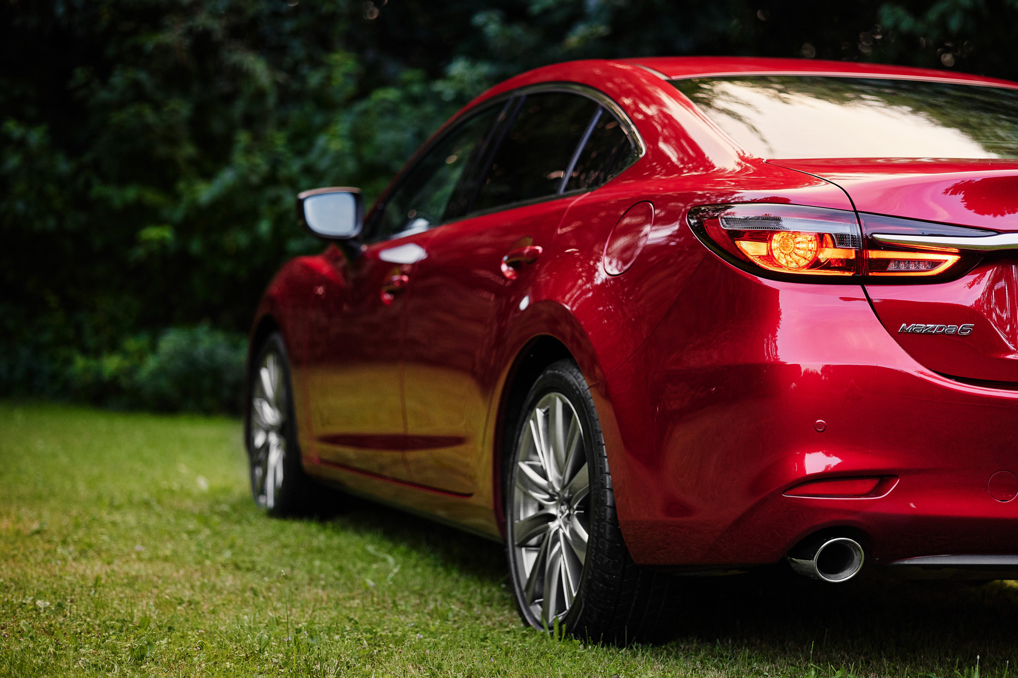 Samochód Mazda zaparkowany pod drzewami